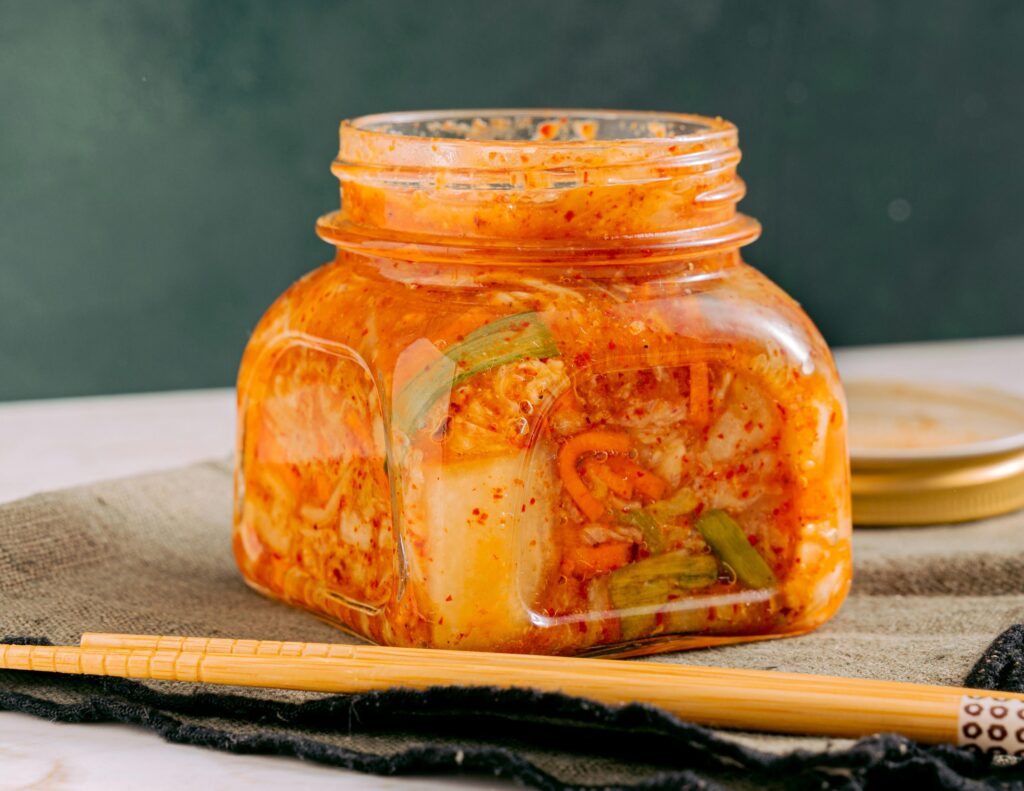 Shredded cabbage fermenting in its own brine inside a glass fermenting jar. One of the best fermented remedies for cold and flue season